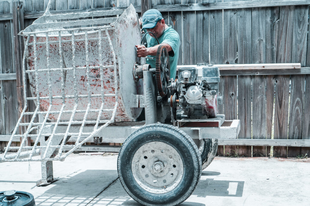 Mechanic Greasing bearings for construction equipment rental.