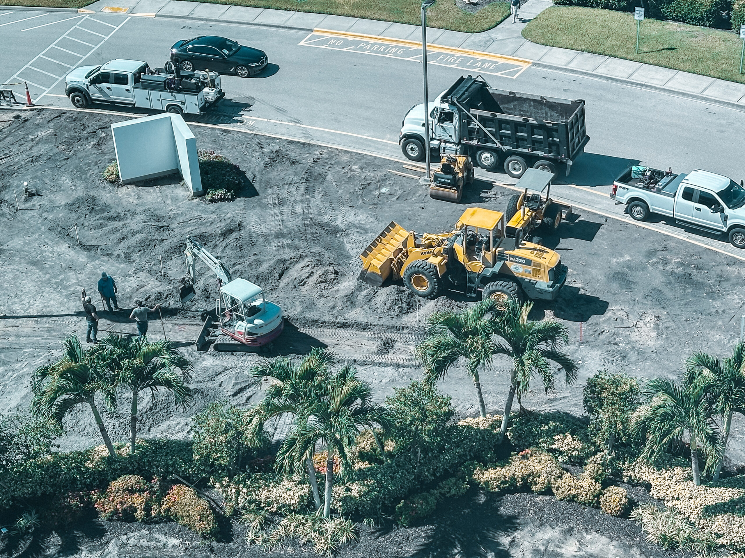 Construction site with excavator rental, front loader, and dump truck in operation for land development.
